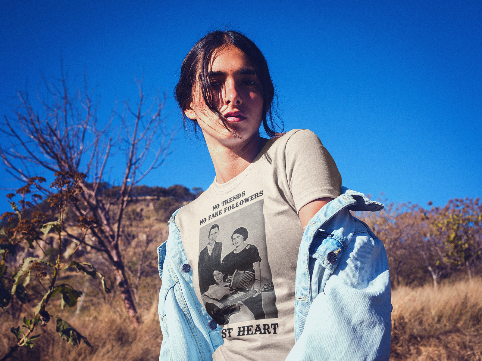 Woman wearing Frontier Rogue No Trends No Fake Follwers Just Heart graphic tee in desert