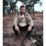 Man wearing Frontier Rogue Tough Times Make Tough People graphic tee in outdoor setting