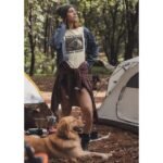 Woman wearing Frontier Rogue Good Dogs Love Good Music graphic tee with dog in outdoor setting