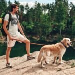 Man wearing Frontier Rogue Good Dogs Love Good Music graphic tee with dog in outdoor setting