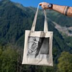 Frontier Rogue Mustang Tote Bag being held over natural scenery